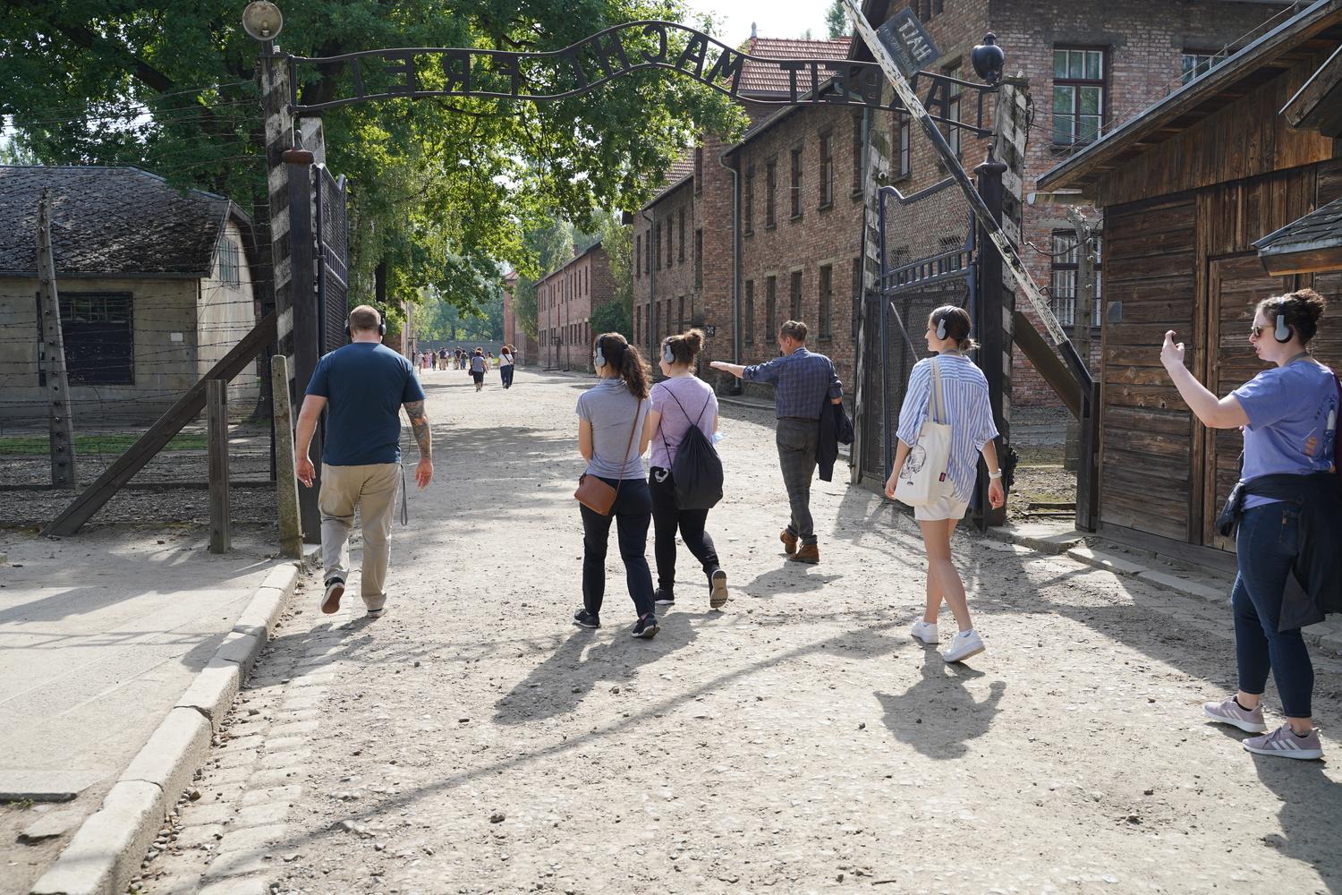 一群对外开放大学的学生和教师走过奥斯威辛集中营的大门